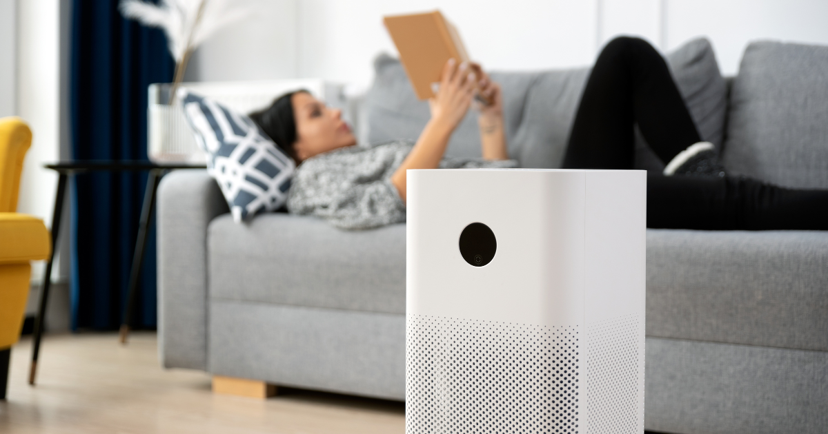 woman relaxing at home with an air purifier to help with her allergies