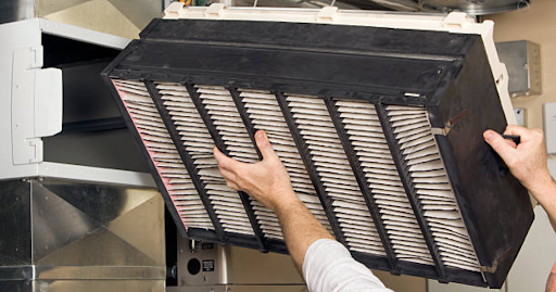 Person changing out air filter for one with a higher merv rating